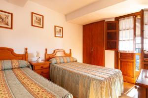 een slaapkamer met 2 bedden en een raam bij Casa Enrique en el oriente de Asturias in Quintana de Llanes