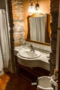 bagno con lavandino e specchio di Hotel Casona D'Alevia ad Alevia