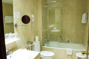 een badkamer met een bad, een toilet en een wastafel bij Atlantis by Atbcn in Barcelona