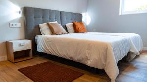 a bedroom with a large bed with white sheets and pillows at Natura Cantabria in Santillana del Mar