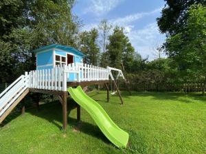 einen Spielplatz mit Rutsche im Gras in der Unterkunft Casa de Los Carpinteros in Les Arriondes