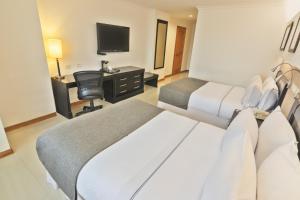 Habitación de hotel con 2 camas y escritorio en Sonesta Hotel Cali en Cali