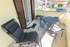 a balcony with a table and chairs on a patio at Apartment Luiza with Terrace in Baška