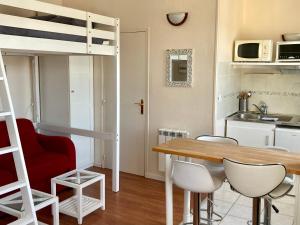Zimmer mit einem Esstisch und einem Hochbett in der Unterkunft Le 22 - Studio 4p Proche Mer & Vue Bourg in Arromanches-les-Bains