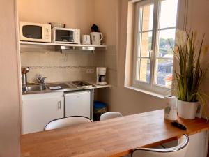 uma cozinha com uma mesa e cadeiras e um lavatório em Le 22 - Studio 4p Proche Mer & Vue Bourg em Arromanches-les-Bains