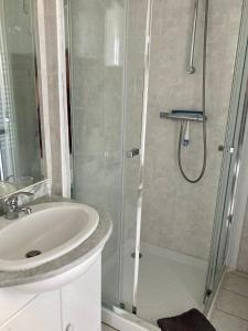 uma casa de banho com um chuveiro e um lavatório. em Le 22 - Studio 4p Proche Mer & Vue Bourg em Arromanches-les-Bains