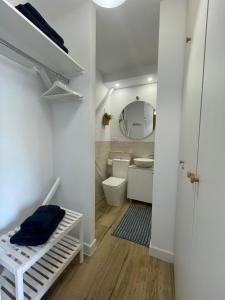 a white bathroom with a toilet and a mirror at Studio on the Beach Front in Sitio de Calahonda