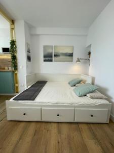 a large white bed in a white room with wood floors at Studio on the Beach Front in Sitio de Calahonda