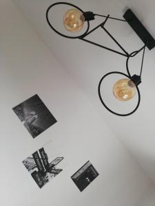 a black chandelier hanging on a white wall with pictures at Studio apartman Noa in Rijeka