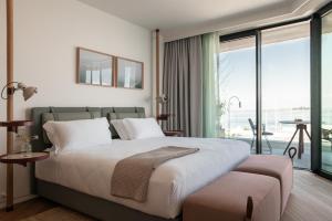 a bedroom with a large bed and a balcony at Laguna Faro Suites - Adults Only in Grado