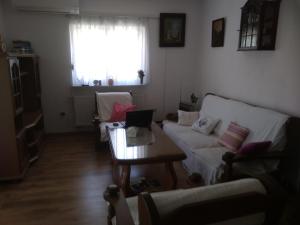 uma sala de estar com um sofá, uma mesa e uma janela em Villa Brabant em Stolac