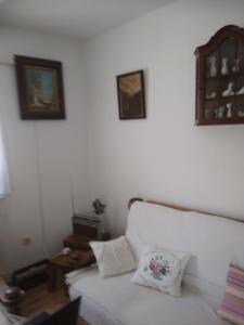 um quarto com uma cama branca e duas fotografias na parede em Villa Brabant em Stolac