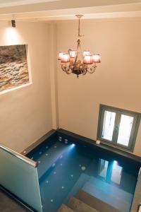 a swimming pool in a room with a chandelier at Katerina's Suite in Plomarion