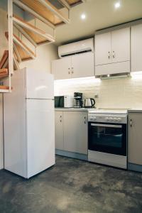 a kitchen with white appliances and white cabinets at Katerina's Suite in Plomari