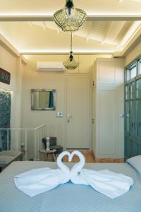 Una cama con un corazón hecho de toallas en Katerina's Suite en Plomari