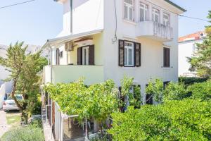 a house with trees in front of it at Apartment Luiza with Terrace in Baška