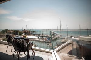 a table and chairs on a balcony with a view of the ocean at Laguna Faro Suites - Adults Only in Grado