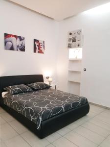a large bed in a white room with pictures on the wall at Studios Centar in Split