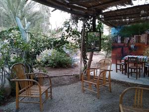 un groupe de chaises et de tables dans un jardin dans l'établissement Departamento Familiar Pimentel - Ica, à Ica