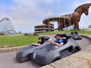 two people riding in a toy car at a roller coaster at MT. OLYMPUS WATER PARK AND THEME PARK RESORT in Wisconsin Dells