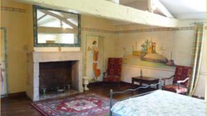 a living room with a bed and a fireplace at Logis de l'Aublonnière in Sainte-Cécile +1 photo