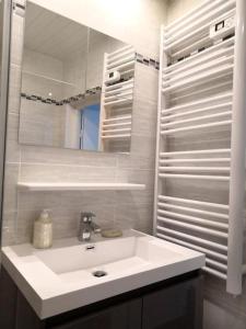 La salle de bains est pourvue d'un lavabo blanc et d'un miroir. dans l'établissement Beautifully Bright Apartment in Old Town Saint-Tropez, à Saint-Tropez