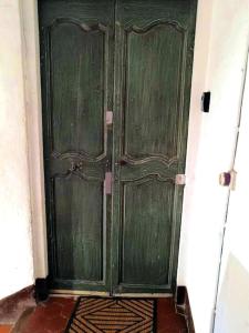 a green wooden door in a room with a floor at Beautifully Bright Apartment in Old Town Saint-Tropez in Saint-Tropez