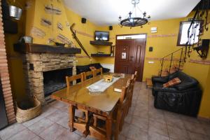 een woonkamer met een tafel en een open haard bij Casa rural de estilo rustico con SPA in Almagro