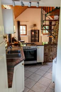 uma cozinha com um lavatório e um fogão forno superior em Le verger de La Haze em Esneux