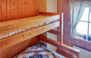 Ce lit superposé se trouve dans une cabane en bois dotée d'une fenêtre. dans l'établissement Amazing Home In Trnaby With Wifi, à Tärnaby