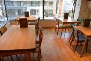 a room with tables and chairs and a large window at Business Inn Norte 2 in Sapporo