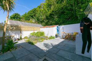a patio with a table and chairs in a backyard at Hillywych Studio in Redruth
