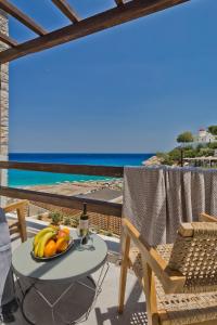 Ypsilos Beach Suites في Kyra Panagia: طبق فاكهة على طاولة في شرفة مع المحيط