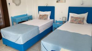 two beds in a room with blue furniture at Babalogo Apartments in Malia