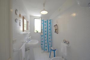 bagno bianco con lavandino e doccia di TRULLO MEDITERRANEO - SANTA MARIA DI LEUCA a Gagliano del Capo