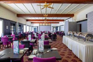 ペイントンにあるThe Esplanade Hotelのテーブル、椅子、紫色の椅子が備わる宴会場