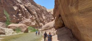 a group of people walking down a river in a canyon at Safi Kitchen Hostel in Aş Şāfī