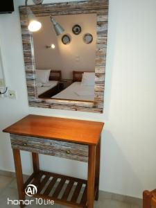 a mirror on a table with a bed in a room at Avra Ηouse in Kriopigi