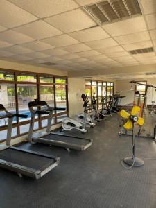 a gym with a row of treadmills and machines at 3BR with pool & gym Apartment by MAS in Dar es Salaam