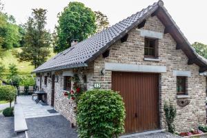 een stenen huis met een garage in een tuin bij Le verger de La Haze in Esneux