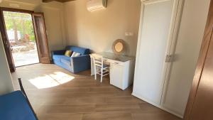 ein Wohnzimmer mit einem blauen Sofa und einem Schreibtisch in der Unterkunft Tenuta Belvedere Cilento in Montecorice