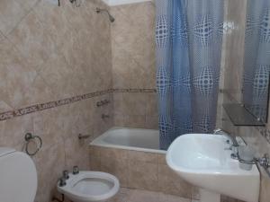 uma casa de banho com um WC, um lavatório e uma banheira em Devoto Rentals em Buenos Aires