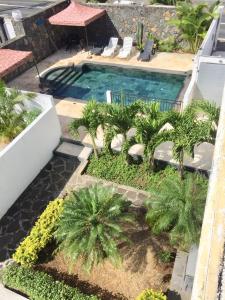 an overhead view of a swimming pool with palm trees at Royal Ho in Grand-Baie