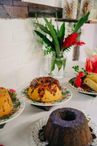una mesa cubierta con platos de pasteles y fruta en Pousada Arraial Lua Crescente, en Arraial d'Ajuda