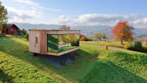 ein kleines Holzhaus auf einem Grasfeld in der Unterkunft WURZENBERG Hotel Lodges Südsteiermark in Gamlitz