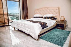 1 dormitorio con 1 cama grande y balcón en Nziza View Hotel, en Kigali