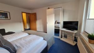 Schlafzimmer mit einem Bett und einem Flachbild-TV in der Unterkunft Ferienwohnung Camping Buchholz in Hamburg