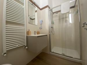 a white bathroom with a shower and a sink at Affittacamere San Michele in San Benedetto del Tronto