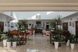 un restaurant avec des tables, des chaises et des plantes en pot dans l'établissement Casa de Higos, à Samarcande