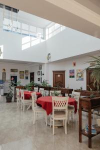 un restaurant avec des tables, des chaises et des nappes rouges dans l'établissement Casa de Higos, à Samarcande